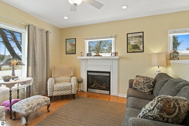112 N Benzie Blvd, Beulah, MI 49617 - living room with a ceiling fan, recessed lighting, a glass covered fireplace, and wood finished floors