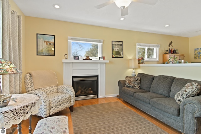 112 N Benzie Blvd, Beulah, MI 49617 - living room with wood finished floors, a glass covered fireplace, baseboards, ceiling fan, and recessed lighting