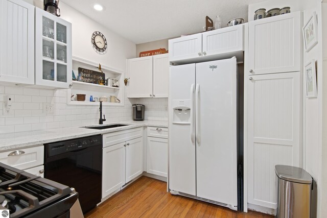 112 N Benzie Blvd, Beulah, MI 49617 - kitchen with white refrigerator with ice dispenser, black dishwasher, a sink, and white cabinetry