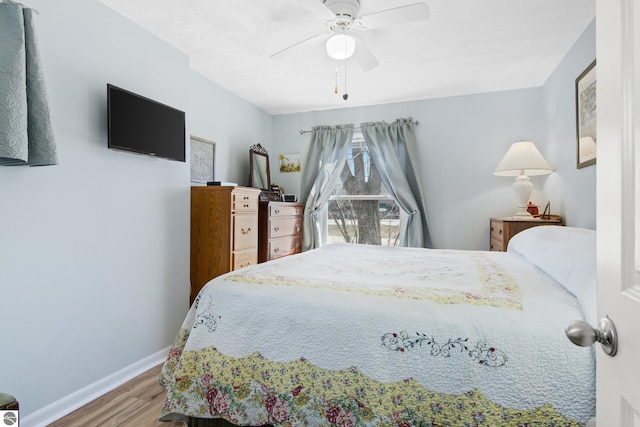 112 N Benzie Blvd, Beulah, MI 49617 - bedroom featuring a ceiling fan, baseboards, and wood finished floors