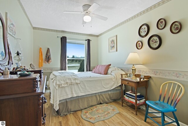 112 N Benzie Blvd, Beulah, MI 49617 - bedroom with wainscoting, ornamental molding, a textured ceiling, and wood finished floors