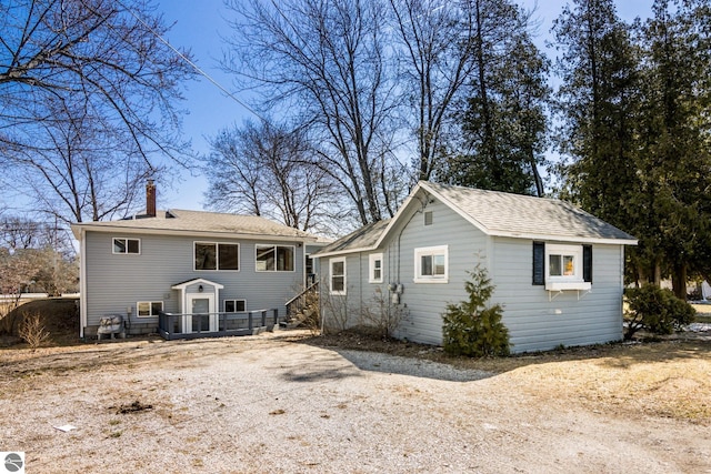 112 N Benzie Blvd, Beulah, MI 49617 - rear view of property with a chimney, an outdoor structure, and roof with shingles