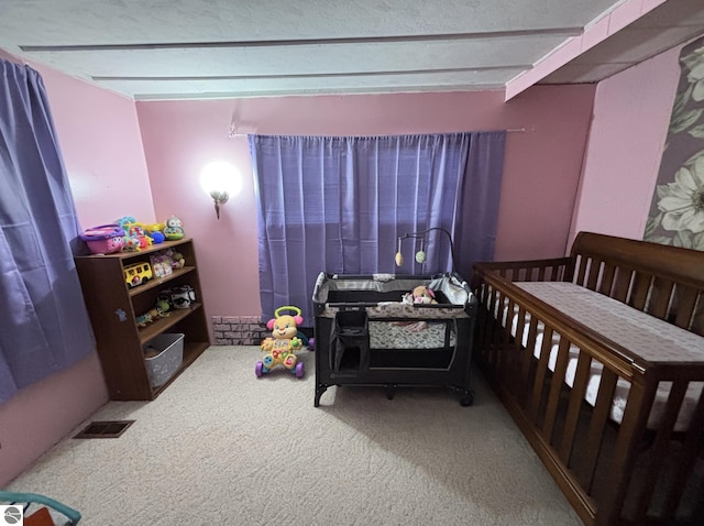 carpeted bedroom with visible vents and beam ceiling