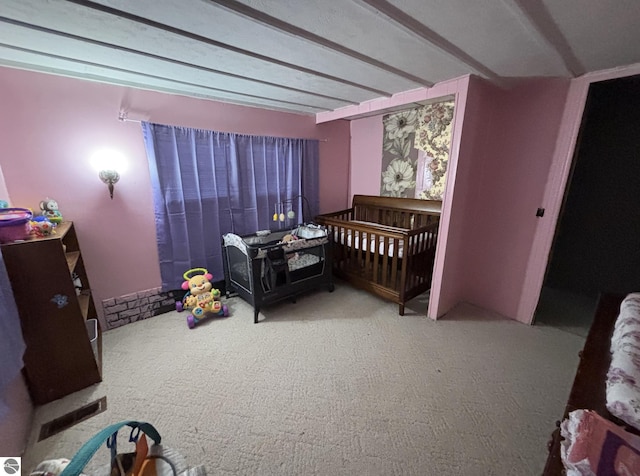 bedroom featuring carpet and beamed ceiling