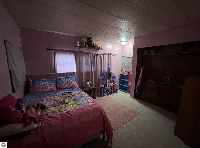bedroom with wooden walls and carpet