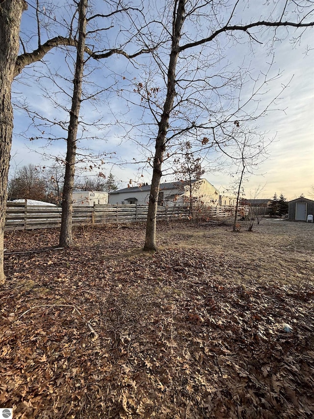 view of yard featuring an outdoor structure and fence
