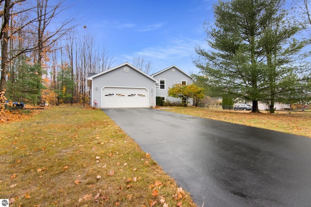 view of front of home with a front yard, aphalt driveway, and an attached garage