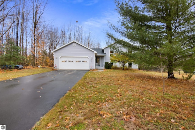 view of front of house featuring driveway, an attached garage, and a front yard