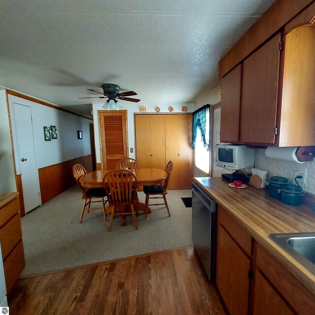4548 Goldenrod Dr, Traverse City, MI 49686 - kitchen with stainless steel dishwasher, white microwave, wood finished floors, a ceiling fan, and a sink