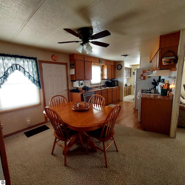 4548 Goldenrod Dr, Traverse City, MI 49686 - dining room with a textured ceiling, ceiling fan, light colored carpet, and baseboards