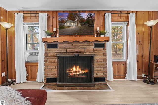 room details featuring visible vents, wooden walls, a fireplace, and wood finished floors