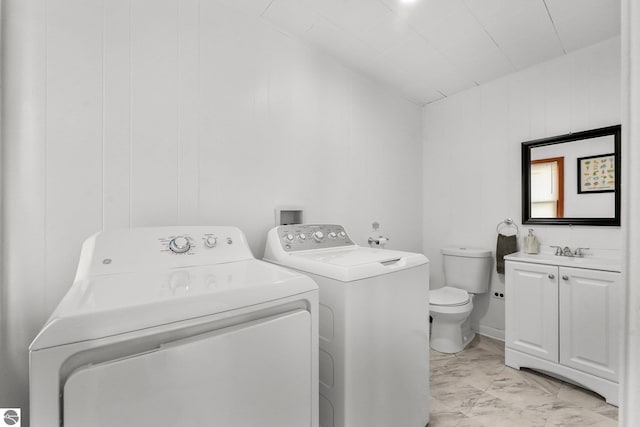 laundry room featuring washing machine and dryer, a sink, laundry area, and marble finish floor