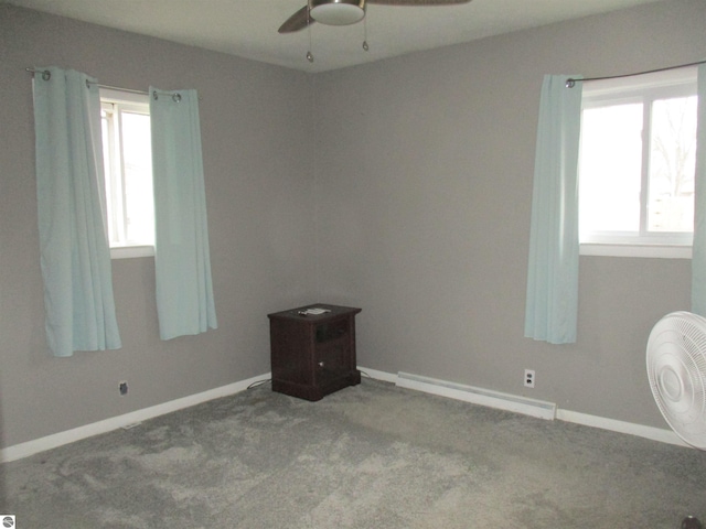 carpeted spare room with baseboards, a baseboard heating unit, and a ceiling fan