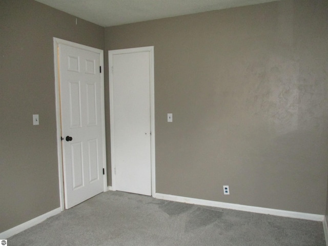 spare room featuring baseboards and carpet floors