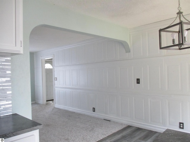 interior space with carpet flooring, a textured ceiling, and a healthy amount of sunlight