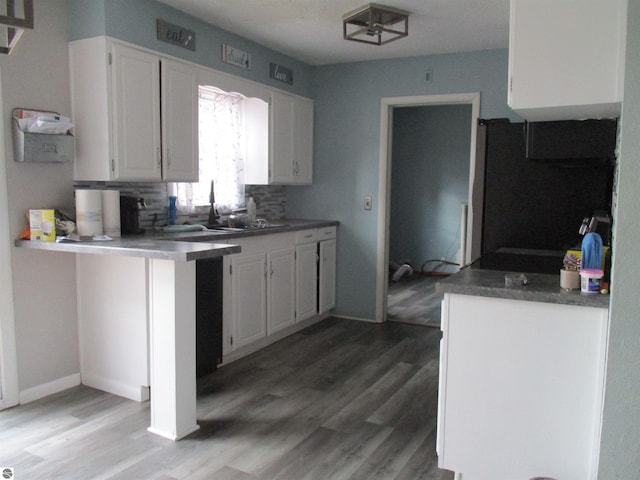 kitchen with tasteful backsplash, light wood-style floors, refrigerator, and white cabinetry