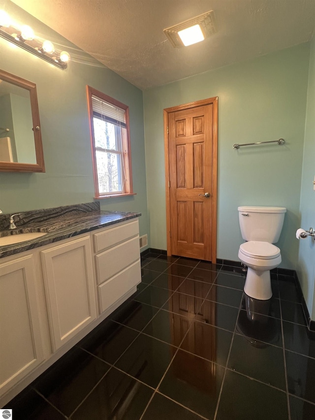 bathroom with visible vents, toilet, a textured ceiling, vanity, and tile patterned flooring