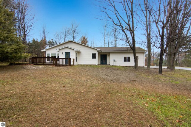 back of house featuring a deck and a lawn