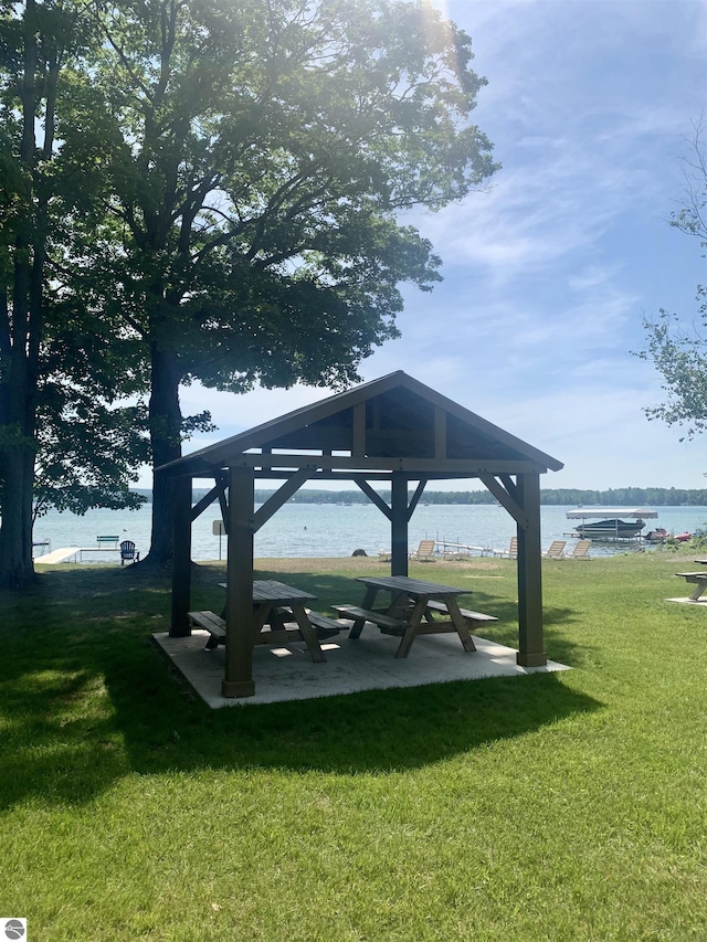 view of property's community with a water view, a gazebo, and a lawn