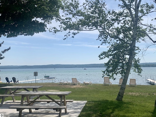 view of property's community with a yard and a water view