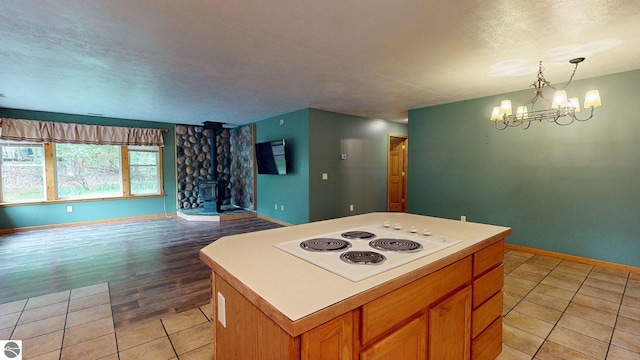 12110 Jonathan Dr, Rapid City, MI 49676 - kitchen featuring white electric stovetop, a textured ceiling, baseboards, open floor plan, and a chandelier