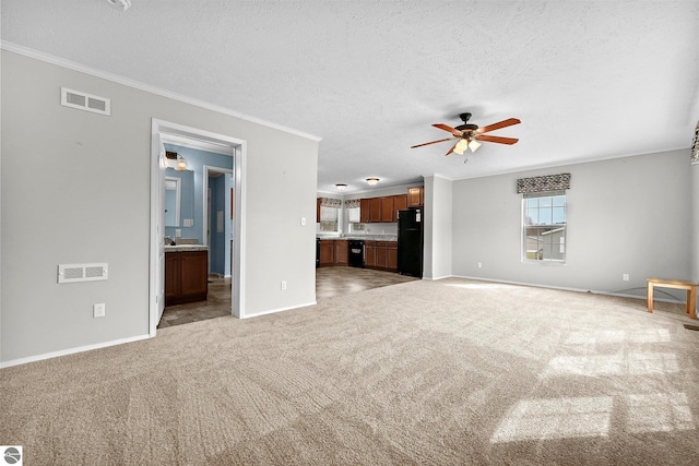 unfurnished living room featuring a textured ceiling, ceiling fan, light colored carpet, and visible vents