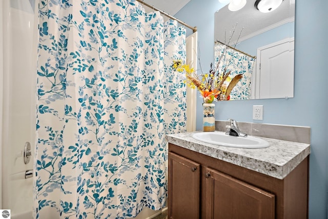 bathroom with a textured ceiling, vanity, a shower with shower curtain, and ornamental molding