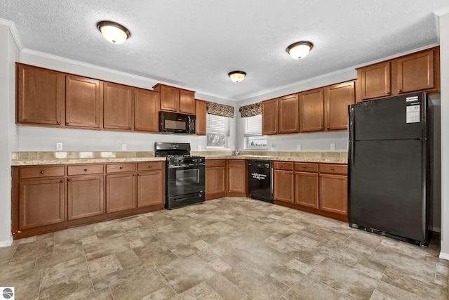 kitchen featuring ornamental molding, light countertops, a textured ceiling, brown cabinets, and black appliances