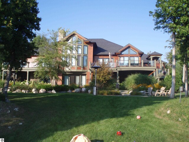 6579 Woods Creek Dr, Charlevoix, MI 49720 - view of front of house with a chimney and a front lawn