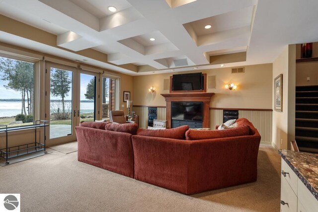 6579 Woods Creek Dr, Charlevoix, MI 49720 - living area with coffered ceiling, light carpet, a glass covered fireplace, and visible vents