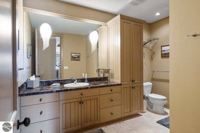 6579 Woods Creek Dr, Charlevoix, MI 49720 - bathroom featuring visible vents, toilet, vanity, and tile patterned flooring