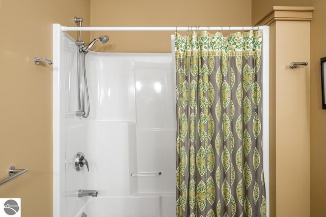 6579 Woods Creek Dr, Charlevoix, MI 49720 - bathroom featuring shower / tub combo with curtain
