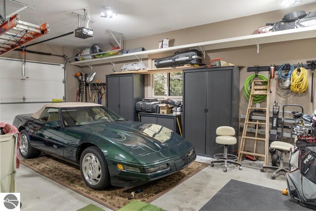 6579 Woods Creek Dr, Charlevoix, MI 49720 - garage featuring a garage door opener
