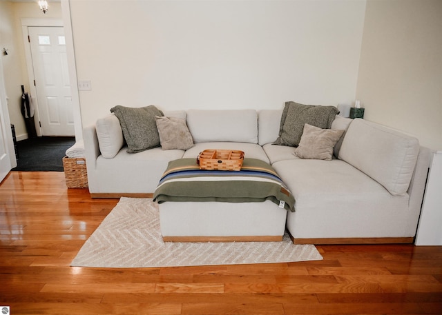 living area with baseboards and wood finished floors