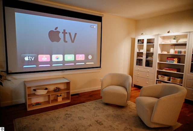 home theater room featuring wood finished floors and baseboards