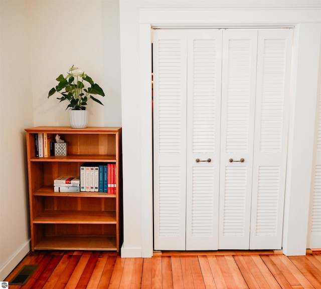 details with wood finished floors, visible vents, and baseboards
