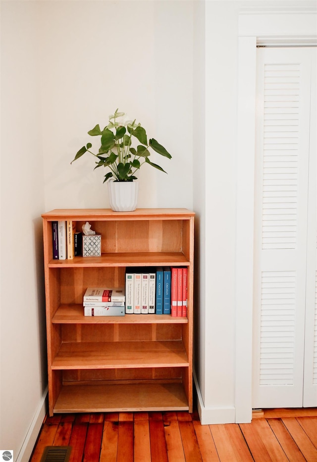 room details featuring baseboards, wood finished floors, and visible vents