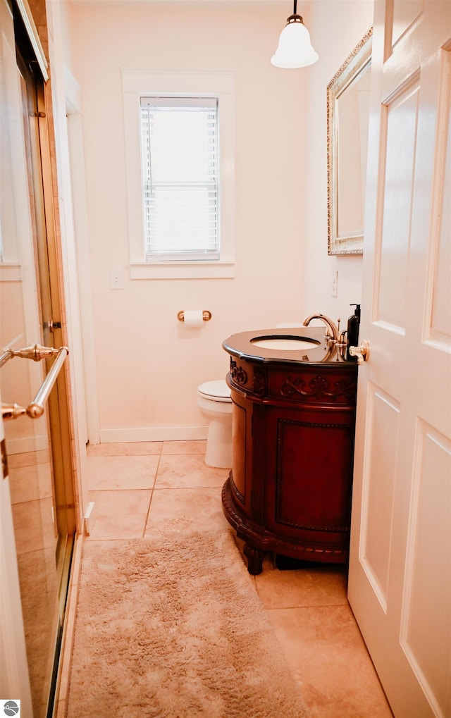 bathroom featuring tile patterned flooring, toilet, vanity, and baseboards