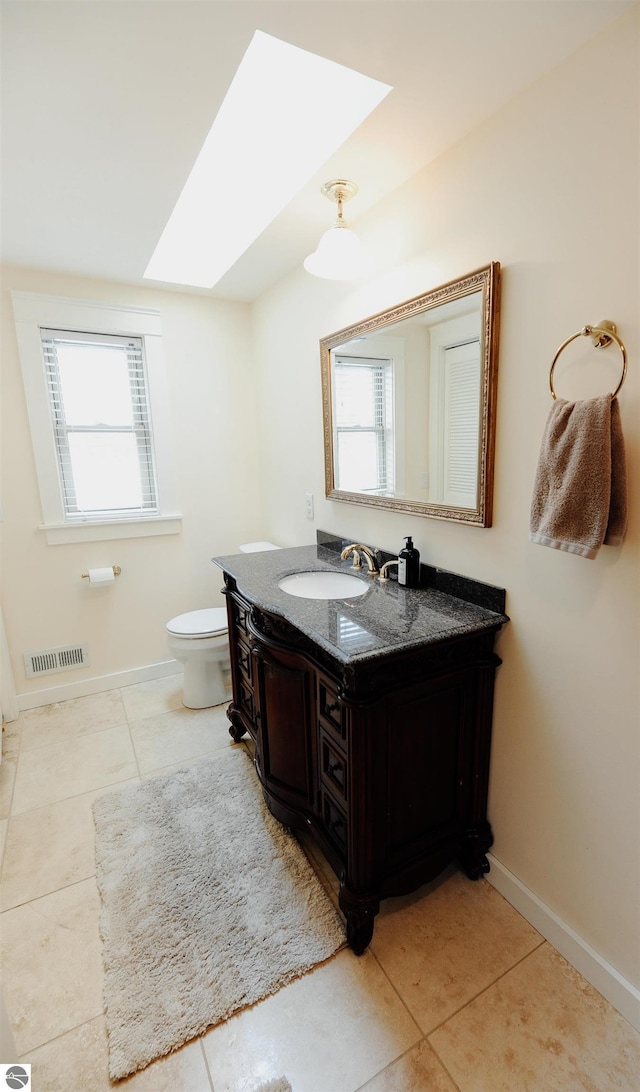 bathroom with plenty of natural light, baseboards, tile patterned flooring, and a skylight