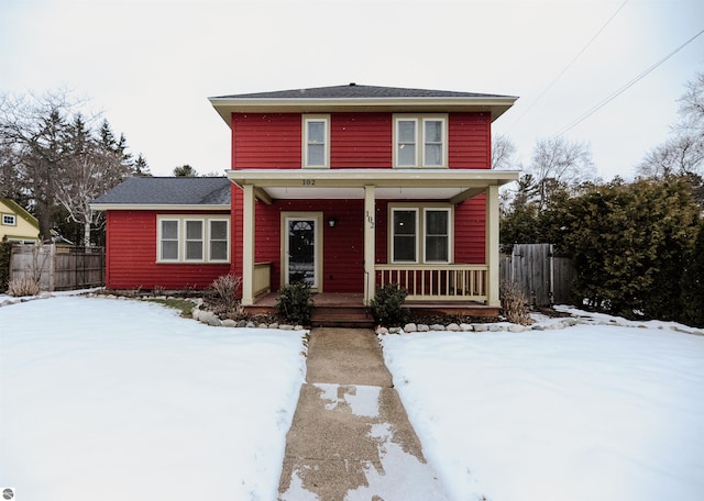 traditional-style home featuring a porch and fence
