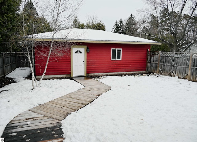 snow covered structure with a fenced backyard