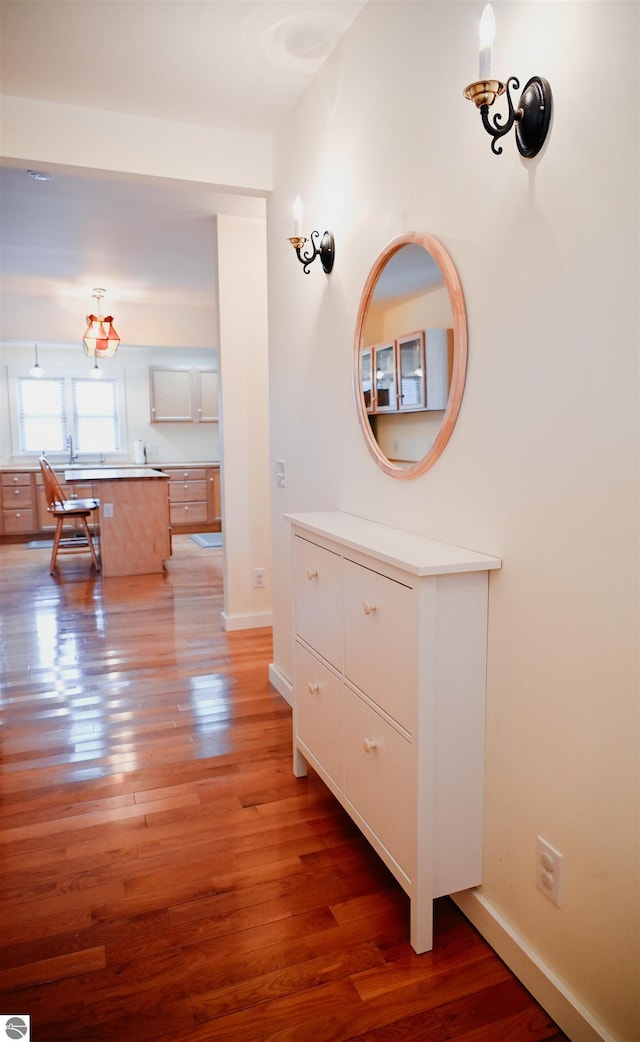hall with baseboards and light wood-type flooring