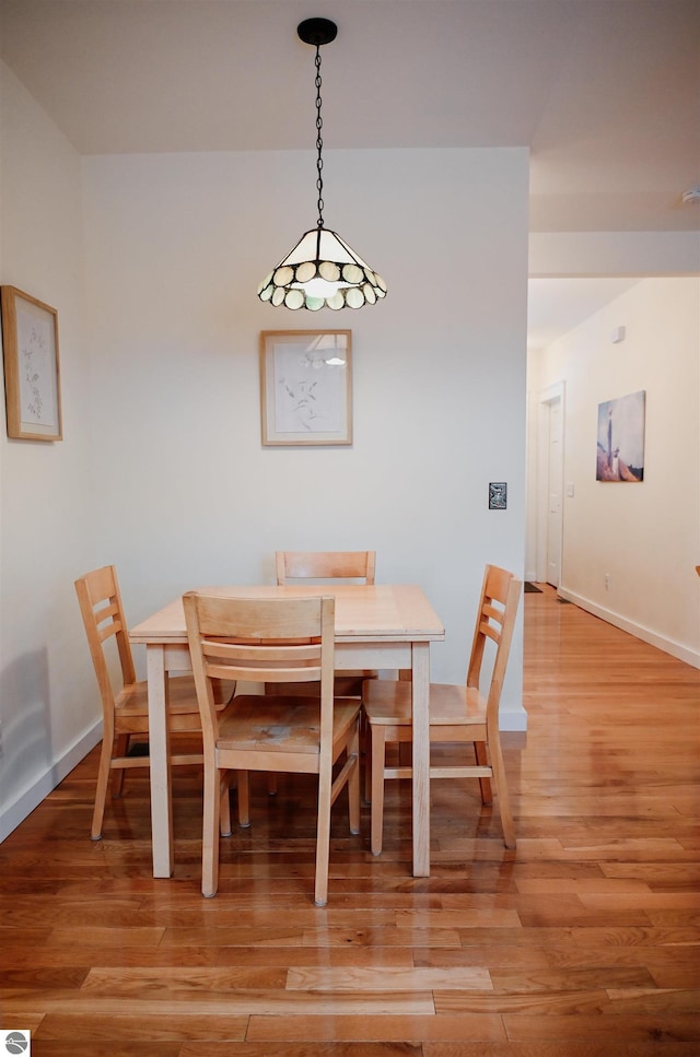 dining space with light wood-style flooring and baseboards