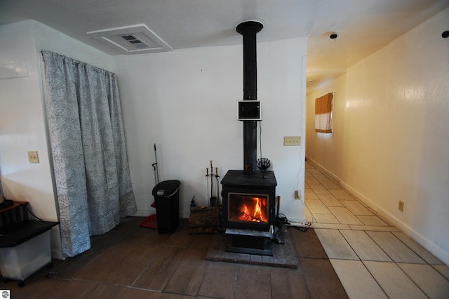 details featuring a wood stove, visible vents, and baseboards