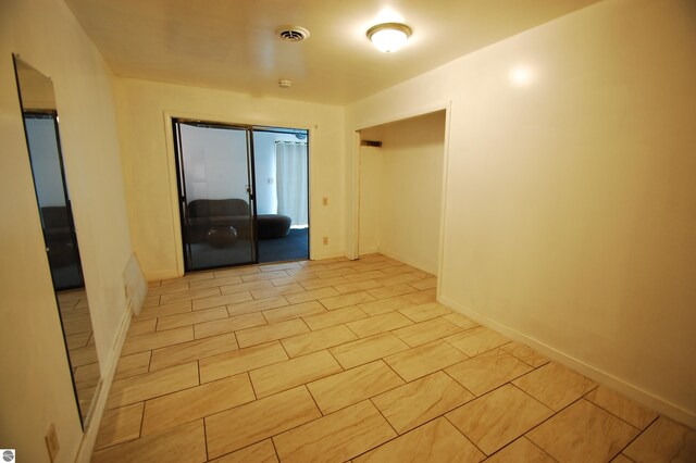unfurnished room with visible vents and baseboards