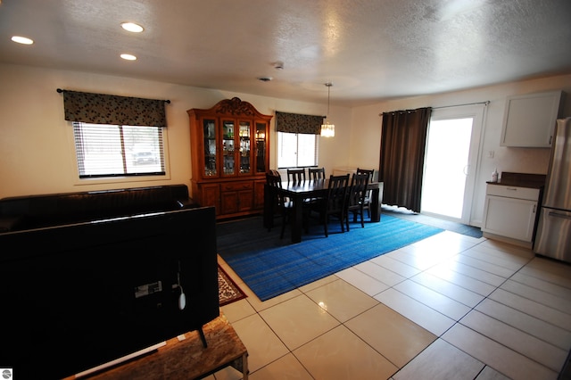 dining area with light tile patterned floors, recessed lighting, and a textured ceiling