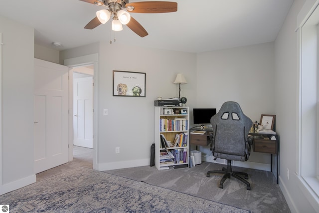 office space with baseboards, a ceiling fan, and carpet