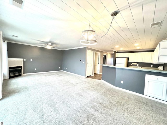 624 S Lake St, Cadillac, MI 49601 - unfurnished living room featuring baseboards, ornamental molding, a ceiling fan, carpet floors, and visible vents