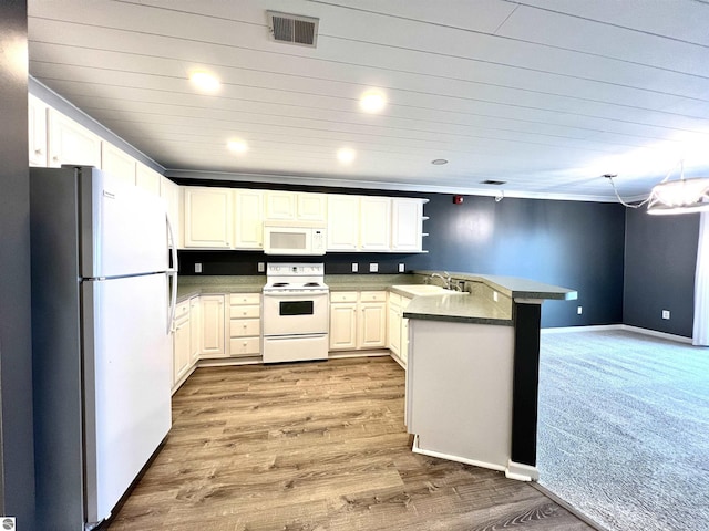 624 S Lake St, Cadillac, MI 49601 - kitchen with white appliances, light wood-style flooring, a peninsula, visible vents, and a sink