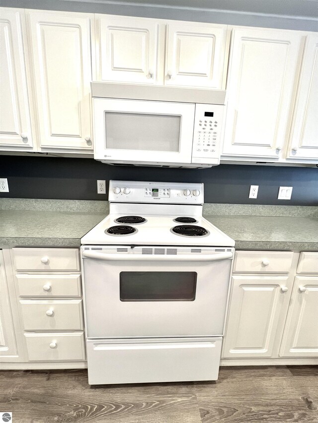 624 S Lake St, Cadillac, MI 49601 - kitchen featuring white cabinets, dark wood-type flooring, and white appliances